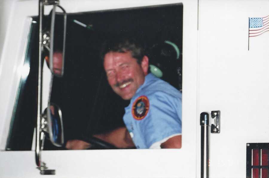 Founder Brian Johnson smiling from the cab of a fire truck